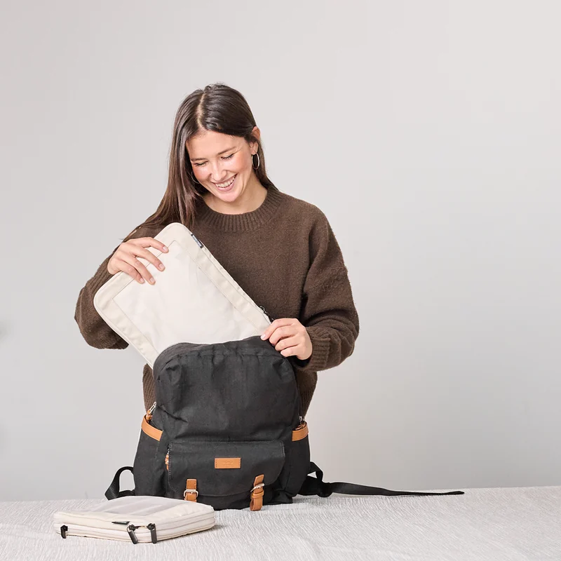 Traveler placing an Aerotrunk packing organizer into a backpack